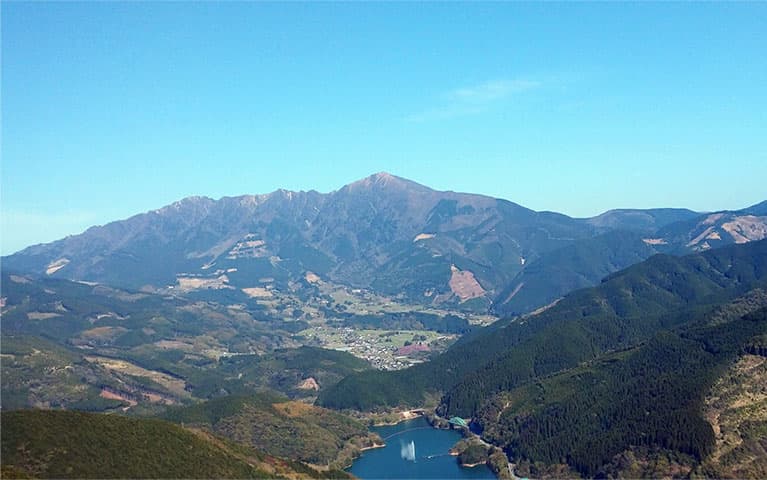 市房ダムの噴水側から見た水上村と市房山の航空写真